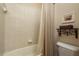 Clean bathroom with white tiled shower, decorative shelving, and a matching shower curtain at 19122 Sunset Bay Dr, Land O Lakes, FL 34638