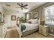 Cozy bedroom featuring a ceiling fan, neutral color palette, and natural light from a large window at 19122 Sunset Bay Dr, Land O Lakes, FL 34638