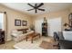 Tan bedroom with a ceiling fan, a couch, two white door closets, and a work desk at 19122 Sunset Bay Dr, Land O Lakes, FL 34638