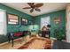 Stylish, green room with sleek desk, colorful rug, and matching curtains at 19122 Sunset Bay Dr, Land O Lakes, FL 34638