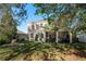 Rear exterior view of home with a brick patio, screened enclosure and spacious yard at 19122 Sunset Bay Dr, Land O Lakes, FL 34638