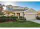 Two-story home featuring a well-manicured lawn and a two-car garage with beautiful stone accents at 19122 Sunset Bay Dr, Land O Lakes, FL 34638