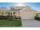 Charming two-story home featuring a manicured lawn and a two-car garage with beautiful stone accents at 19122 Sunset Bay Dr, Land O Lakes, FL 34638