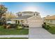 Charming two-story home with a well-manicured lawn, inviting entrance, and attached two car garage at 19122 Sunset Bay Dr, Land O Lakes, FL 34638
