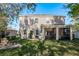 View of rear exterior showing brick patio, backyard, and screened in porch at 19122 Sunset Bay Dr, Land O Lakes, FL 34638