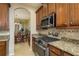 Kitchen with stainless steel oven, tile backsplash, granite countertops, and an adjacent dining area at 19122 Sunset Bay Dr, Land O Lakes, FL 34638