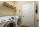 A well-equipped laundry room features modern washer and dryer units and wire rack at 19122 Sunset Bay Dr, Land O Lakes, FL 34638