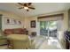 Inviting living room with a ceiling fan, comfortable seating, and sliding glass doors to the outside at 19122 Sunset Bay Dr, Land O Lakes, FL 34638