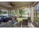 Screened-in patio with table and chairs overlooking a serene lake and manicured lawn at 19122 Sunset Bay Dr, Land O Lakes, FL 34638