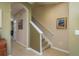 Carpeted staircase ascends in the home with beige walls, white trim, and an arched doorway at 19122 Sunset Bay Dr, Land O Lakes, FL 34638