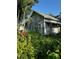 Quaint home with covered porch, partially boarded, surrounded by lush landscaping at 2980 64Th N Ave, St Petersburg, FL 33702