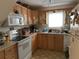 Functional kitchen with wood cabinets, a white appliance suite, and a bright window for natural light at 2980 64Th N Ave, St Petersburg, FL 33702