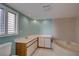 Bathroom featuring a corner bathtub, tiled walls, and a large vanity with a sink at 3200 Charter Club Dr # A1, Tarpon Springs, FL 34688