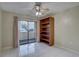 Bedroom with tile flooring, ceiling fan, bookshelf, and sliding glass door to outdoor patio at 3200 Charter Club Dr # A1, Tarpon Springs, FL 34688