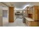 Galley-style kitchen with white cabinets, stainless steel appliances, and tile flooring at 3200 Charter Club Dr # A1, Tarpon Springs, FL 34688