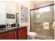 Bathroom featuring granite counters, cherry cabinets, and a glass enclosed shower at 328 Siena Vista Pl, Sun City Center, FL 33573