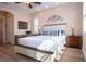 Bedroom with wood floors, decorative headboard, and white bedding with blue striped pillows at 328 Siena Vista Pl, Sun City Center, FL 33573