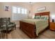 Bedroom with wood frame bed, wood floors, and white shutters at 328 Siena Vista Pl, Sun City Center, FL 33573