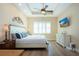 Bedroom featuring tray ceiling with fan, hardwood floors, and white shutters on window at 328 Siena Vista Pl, Sun City Center, FL 33573