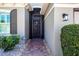 Charming front entrance featuring a decorative security door, brick walkway, and manicured shrubs at 328 Siena Vista Pl, Sun City Center, FL 33573