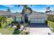 Beautiful single-story home with a well-manicured lawn, lush landscaping, and a brick paver driveway at 328 Siena Vista Pl, Sun City Center, FL 33573
