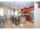 Kitchen with stainless steel appliances, a center island with barstool seating, and a view of the dining area at 328 Siena Vista Pl, Sun City Center, FL 33573