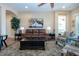 Cozy living room with a leather sofa, ceiling fan, and a large barn painting on the wall at 328 Siena Vista Pl, Sun City Center, FL 33573