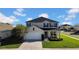 Inviting two-story home featuring a manicured lawn, attached two-car garage, and neutral-toned exterior at 3301 San Moise Pl, Plant City, FL 33567