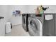 Modern laundry room with gray washer and dryer, tile flooring, and ample storage space at 3301 San Moise Pl, Plant City, FL 33567
