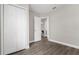 Bedroom with wood-look floors and a view of a closet and the hallway with open doors at 3512 E 23Rd Ave, Tampa, FL 33605