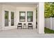 Cozy back porch with outdoor seating, white columns, and a view of the green yard for relaxing at 3618 W Royal Palm Cir, Tampa, FL 33629