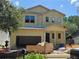 Exterior view of a two-story home under construction showing garage, door, and a ladder against the roof at 3618 W Royal Palm Cir, Tampa, FL 33629