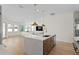 Open kitchen featuring an island with sink, hardwood floors, stainless steel appliances, and modern pendant lighting at 3618 W Royal Palm Cir, Tampa, FL 33629