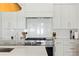 White kitchen features modern stainless steel appliances, stylish range hood, and white countertops at 3618 W Royal Palm Cir, Tampa, FL 33629