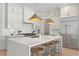Bright kitchen features white cabinetry, stainless steel appliances, and a center island with bar stool seating at 3618 W Royal Palm Cir, Tampa, FL 33629