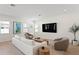 Cozy living room featuring modern furniture, a large TV, neutral decor, and an abundance of natural light at 3618 W Royal Palm Cir, Tampa, FL 33629