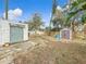 View of the backyard showing sheds, partially shaded areas, and some mature trees at 4827 7Th N Ave, St Petersburg, FL 33713