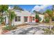 Charming bungalow-style home featuring a textured facade, vibrant orange accents, and mature landscaping at 4827 7Th N Ave, St Petersburg, FL 33713