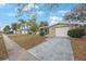 Cozy single-story home featuring a curved screened porch and a paved driveway leading to a garage at 5317 Tammy Ln, Holiday, FL 34690