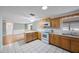 The kitchen offers wood cabinetry, tile floors, and a breakfast bar that connects to a dining space at 5317 Tammy Ln, Holiday, FL 34690