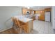 Eat-in kitchen offers a breakfast bar with seating, wood cabinetry, white appliances and tile flooring at 5317 Tammy Ln, Holiday, FL 34690