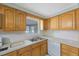 The kitchen features wood cabinets, double stainless sink, dishwasher and white subway tile backsplash at 5317 Tammy Ln, Holiday, FL 34690