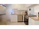 Well-equipped kitchen area featuring stainless steel appliances, granite countertops, and neutral tile floor at 6800 Sunset Way # 1003, St Pete Beach, FL 33706
