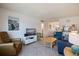 Living room with tile floors, a shiplap wall, comfortable seating, and an open layout at 6800 Sunset Way # 1003, St Pete Beach, FL 33706
