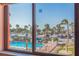 Bright view of pool, palm trees, and beach access from the condo's large, sunlit windows at 6800 Sunset Way # 1003, St Pete Beach, FL 33706