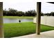 View of a backyard featuring green grass, a fence and a pond at 8438 Wheat Stone Dr, Zephyrhills, FL 33540