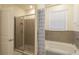 Bright bathroom featuring a tub with shower, tile surround, and window at 8438 Wheat Stone Dr, Zephyrhills, FL 33540