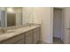 Well-lit bathroom with double vanity, granite countertop, and a large mirror at 8438 Wheat Stone Dr, Zephyrhills, FL 33540