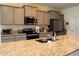 Spacious kitchen with granite countertops, stainless steel appliances, and bar seating at 8438 Wheat Stone Dr, Zephyrhills, FL 33540