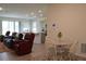 Open concept living room with tile floors and a view into the kitchen at 8438 Wheat Stone Dr, Zephyrhills, FL 33540